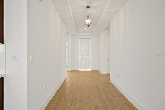 hall with a tray ceiling and light hardwood / wood-style floors