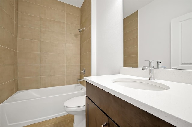 full bathroom featuring vanity, hardwood / wood-style flooring, toilet, and tiled shower / bath