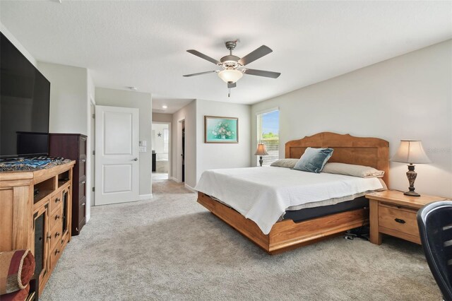 bedroom featuring light colored carpet and ceiling fan