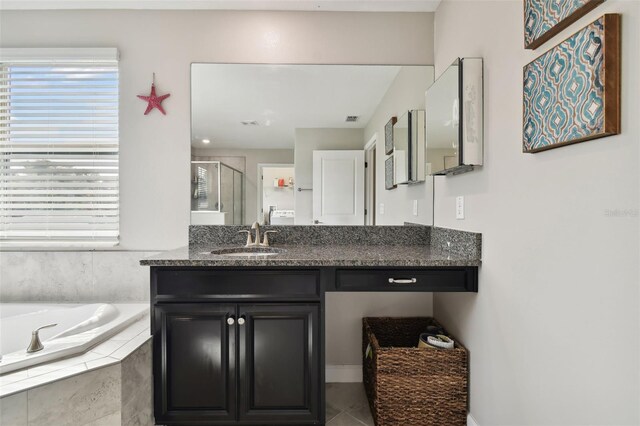 bathroom with vanity, tile patterned floors, and plus walk in shower