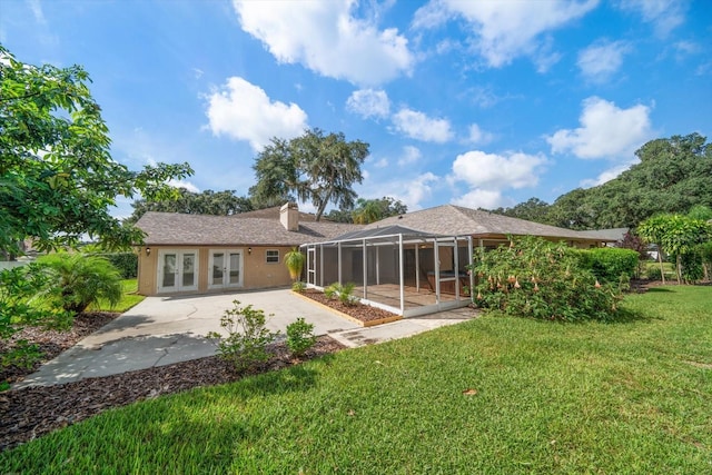 back of property with a patio area, a yard, and french doors