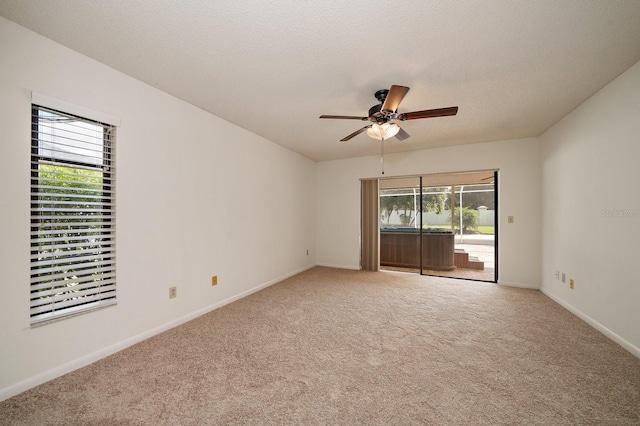 carpeted spare room with ceiling fan and a textured ceiling