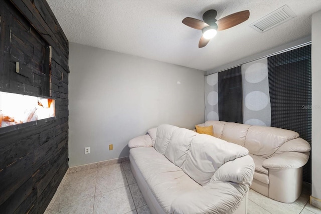 living room with ceiling fan and a textured ceiling