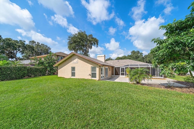 rear view of property featuring a patio area, a lanai, and a lawn