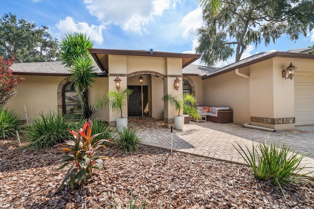 rear view of property featuring a patio area and a garage