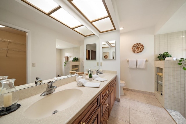 bathroom featuring tile patterned floors, vanity, toilet, and a fireplace