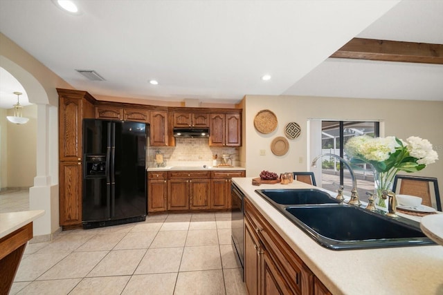 kitchen featuring tasteful backsplash, black appliances, sink, beamed ceiling, and light tile patterned floors