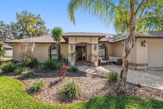 view of front of house with an attached garage, an outdoor hangout area, and stucco siding