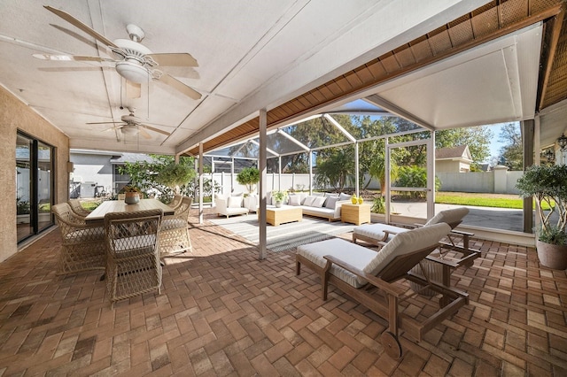 view of patio / terrace with fence, ceiling fan, an outdoor hangout area, and a lanai