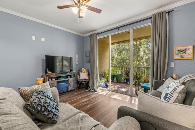 living room with ornamental molding, ceiling fan, and dark wood-type flooring