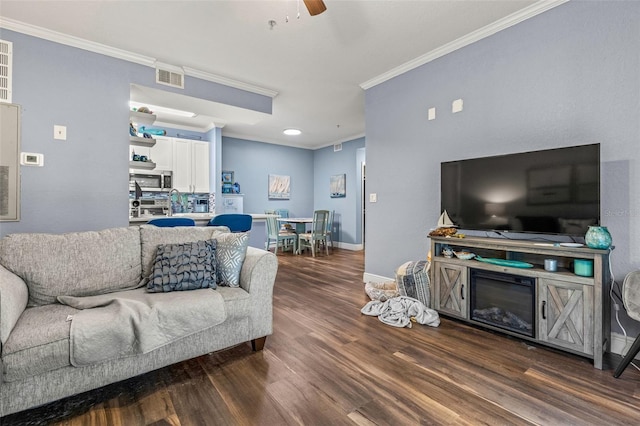 living room featuring ceiling fan, crown molding, and dark hardwood / wood-style floors