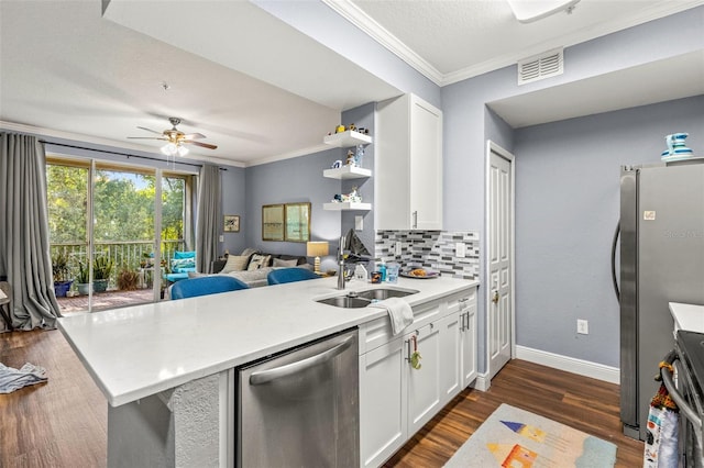 kitchen with appliances with stainless steel finishes, tasteful backsplash, white cabinetry, and kitchen peninsula