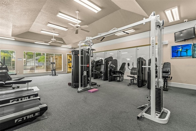 gym featuring a textured ceiling, ceiling fan, and vaulted ceiling