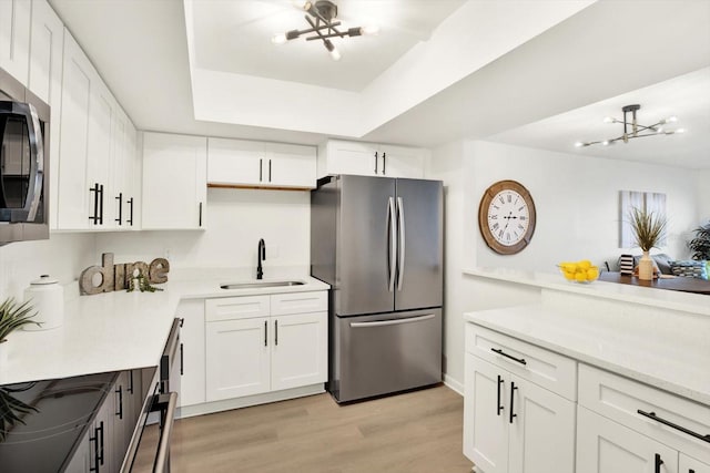 kitchen featuring white cabinets, light hardwood / wood-style floors, stainless steel appliances, and sink