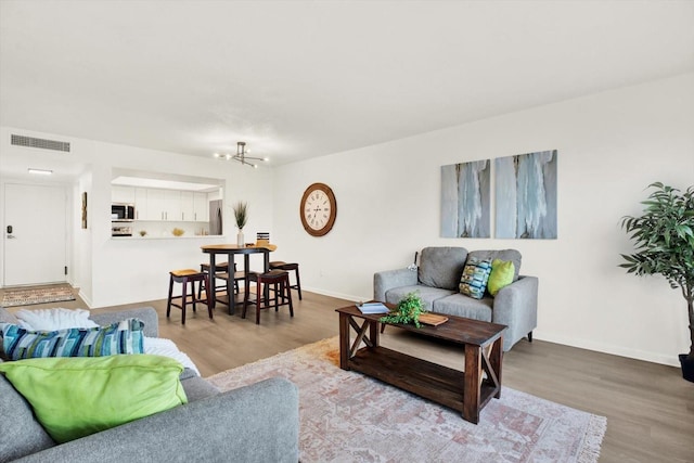 living room featuring an inviting chandelier and hardwood / wood-style floors