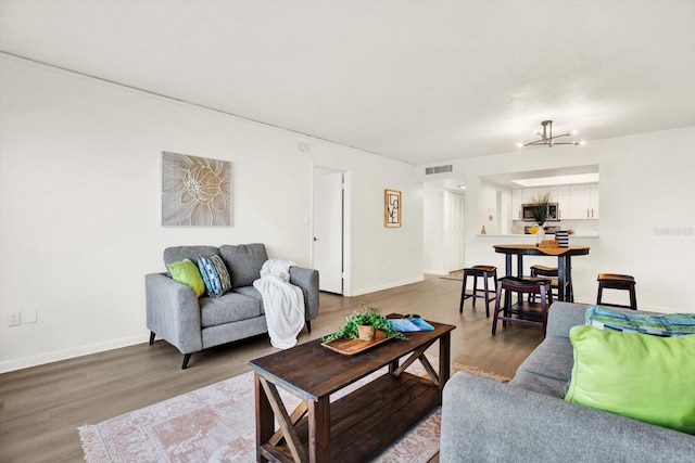 living room with a notable chandelier and hardwood / wood-style flooring