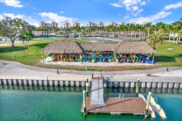 view of dock with a yard and a water view