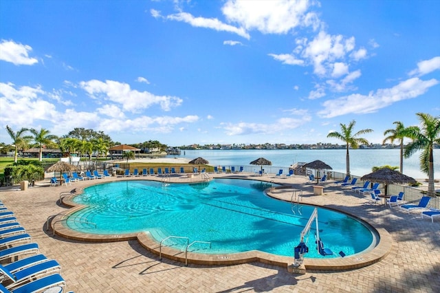 view of swimming pool featuring a water view and a patio area