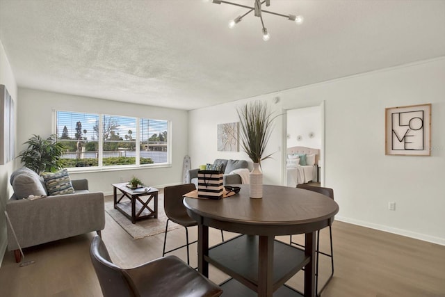 dining room featuring a notable chandelier, hardwood / wood-style floors, and a textured ceiling