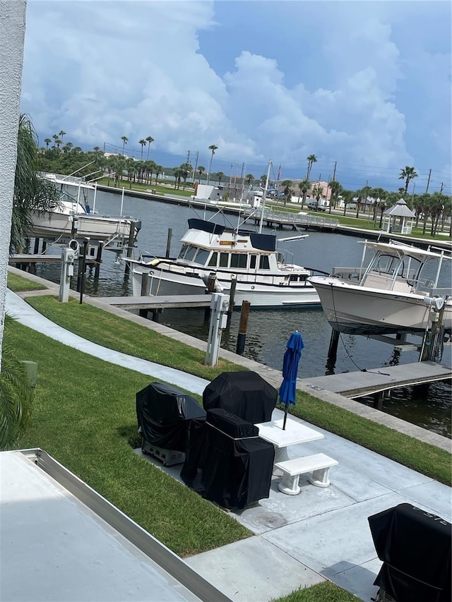 view of dock with a water view and a yard