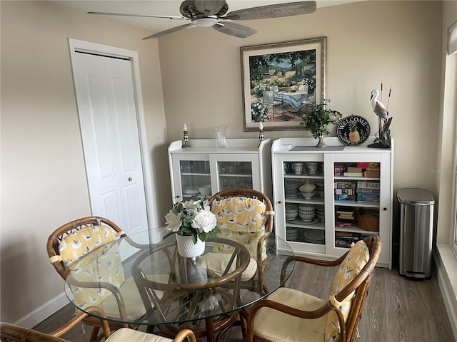 dining space with dark wood-type flooring and ceiling fan