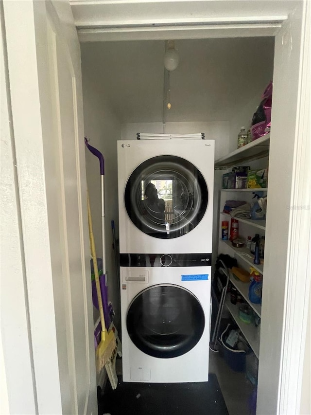 clothes washing area featuring stacked washer / dryer