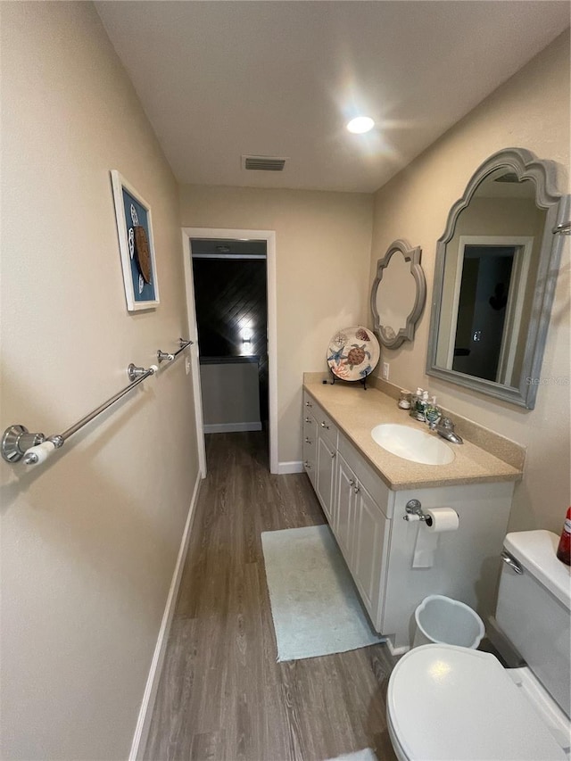 bathroom featuring vanity, toilet, and hardwood / wood-style flooring