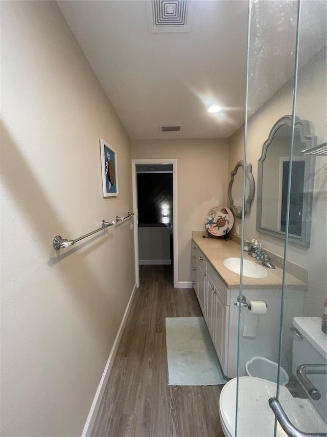 bathroom with vanity, toilet, and hardwood / wood-style flooring