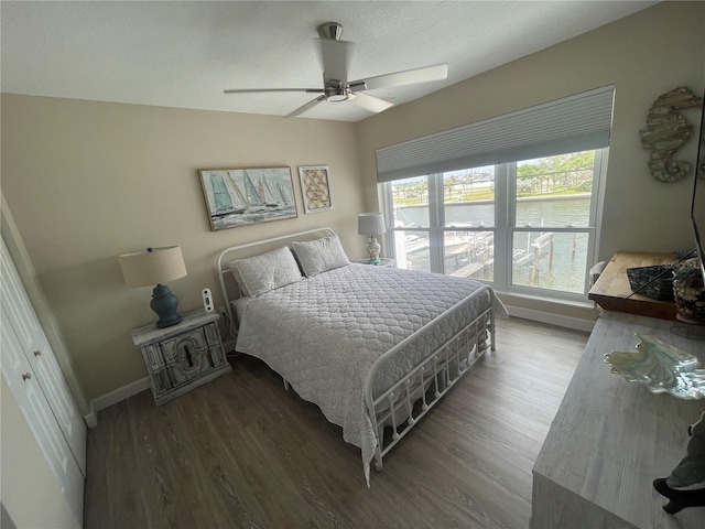 bedroom with a textured ceiling, hardwood / wood-style flooring, ceiling fan, and a closet