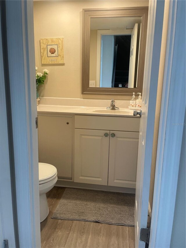 bathroom featuring vanity, toilet, and hardwood / wood-style flooring