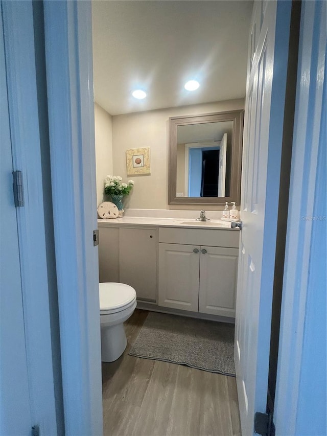 bathroom featuring vanity, toilet, and hardwood / wood-style flooring