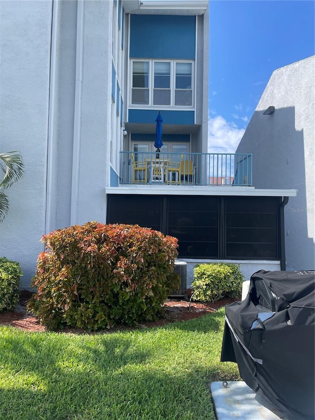 view of home's exterior featuring a yard and a balcony