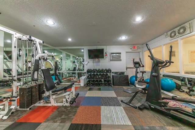 workout area featuring a wall unit AC and a textured ceiling