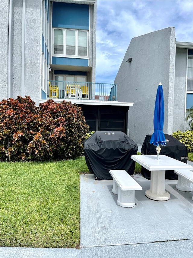 exterior space featuring a balcony and a lawn