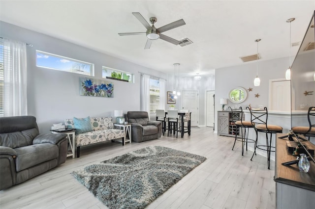 living room with light wood-type flooring and ceiling fan