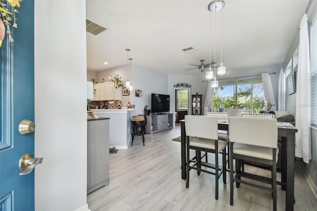 dining area with light hardwood / wood-style flooring and ceiling fan