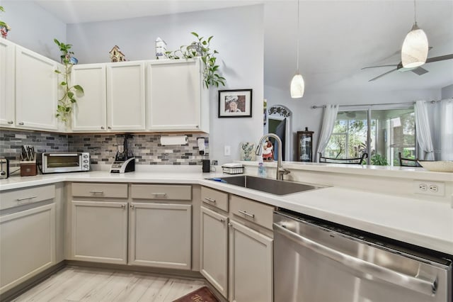 kitchen with stainless steel dishwasher, ceiling fan, sink, and decorative light fixtures