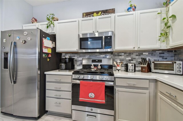 kitchen with white cabinetry, stainless steel appliances, and decorative backsplash