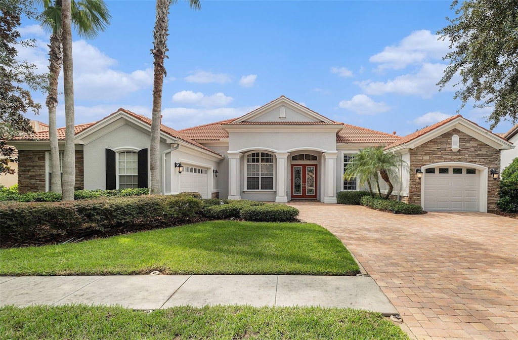 mediterranean / spanish house with a front yard and a garage