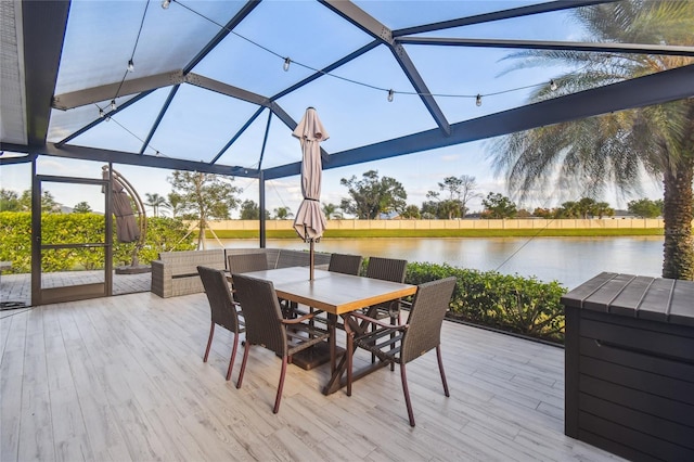 deck with glass enclosure and a water view