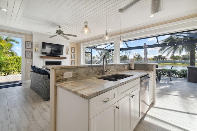 kitchen featuring white cabinets, light stone countertops, pendant lighting, ceiling fan, and sink