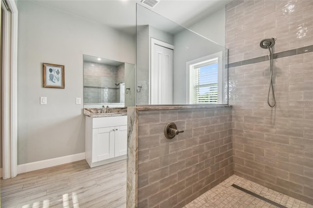 bathroom featuring a tile shower and vanity