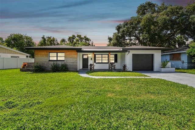 single story home with a garage and a yard