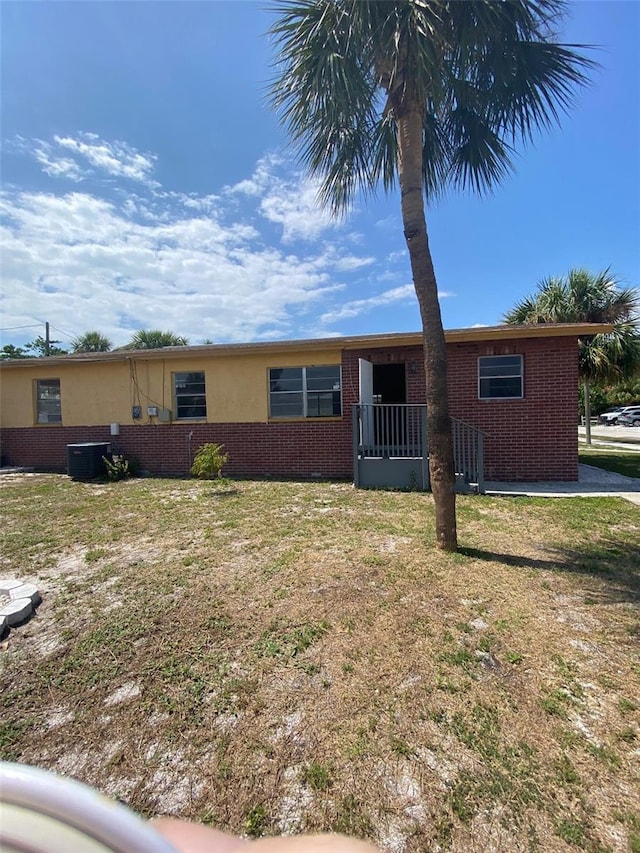 single story home featuring central AC unit and a front yard