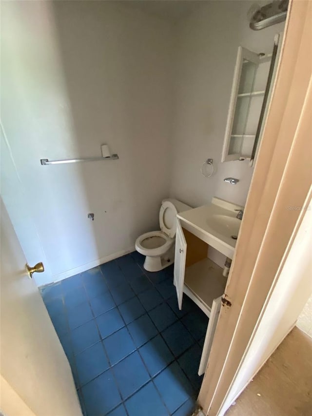 bathroom featuring tile patterned flooring, vanity, and toilet