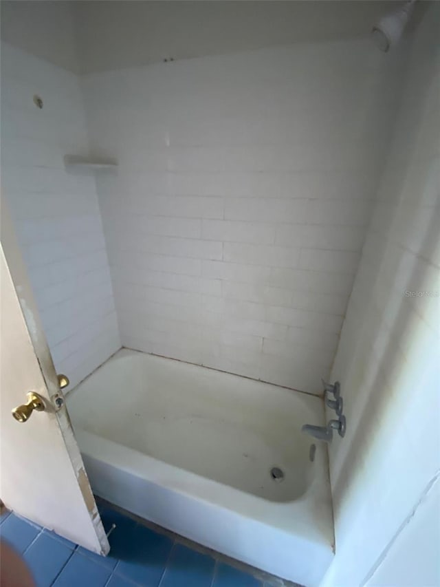 bathroom featuring tiled shower / bath combo and tile patterned flooring