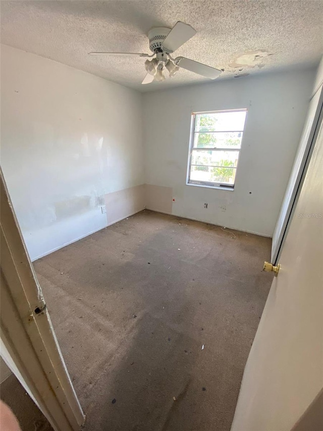 carpeted empty room featuring a textured ceiling and ceiling fan