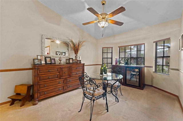 carpeted dining area featuring ceiling fan and vaulted ceiling