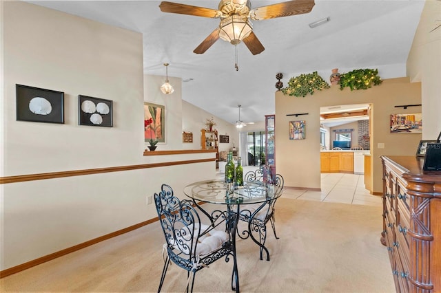 dining area featuring light carpet, vaulted ceiling, and ceiling fan