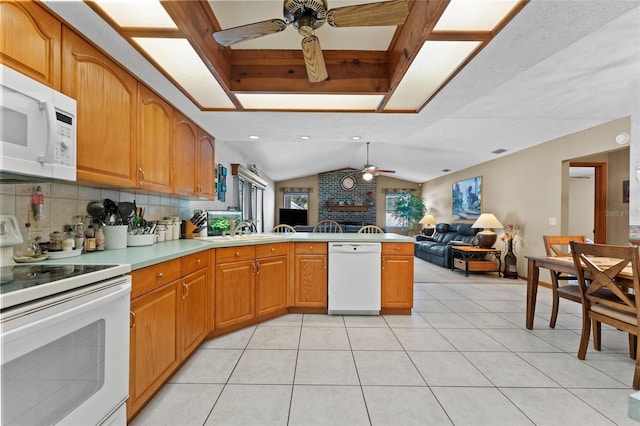 kitchen featuring white appliances, kitchen peninsula, ceiling fan, decorative backsplash, and vaulted ceiling